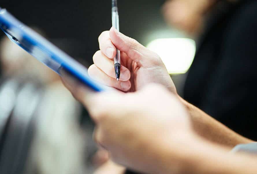 Image of a duty holder using a clipboard to make notes about an asbestos register.